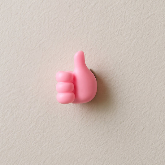 Pink hand-shaped wall clip holder made of silicone on white background