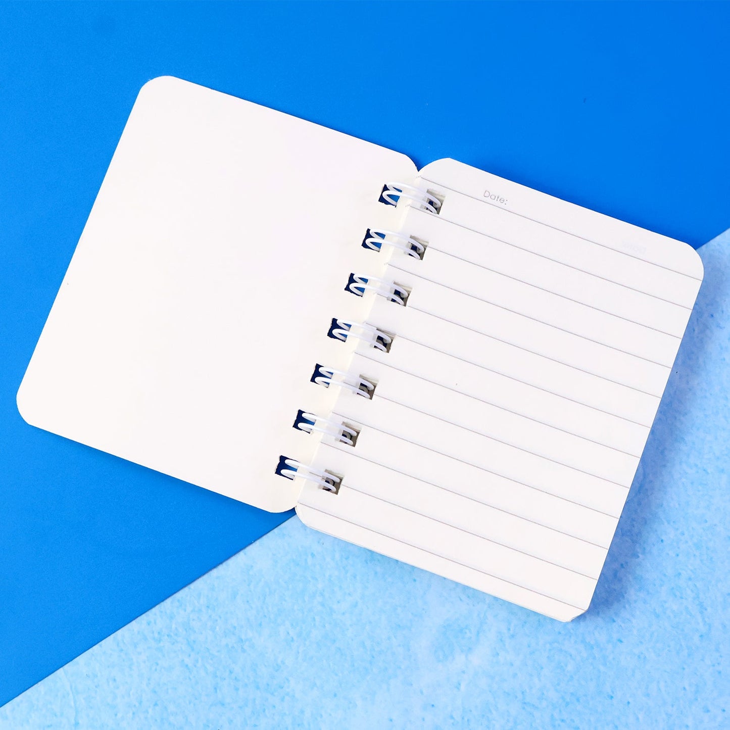 Open spiral bound pocket notebook with ruled writing pages