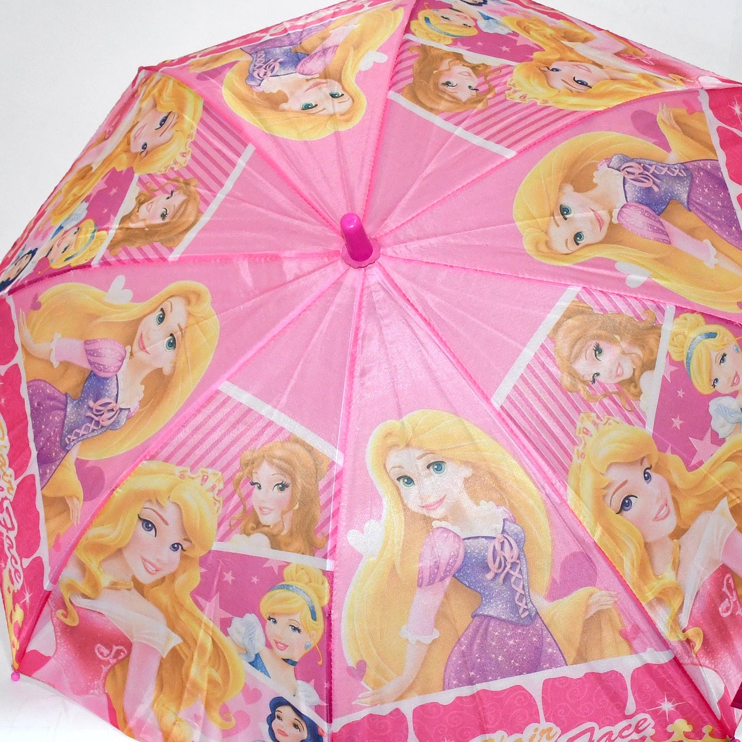A close-up view of the pink umbrella canopy shows multiple cartoon princesses with long blonde hair.