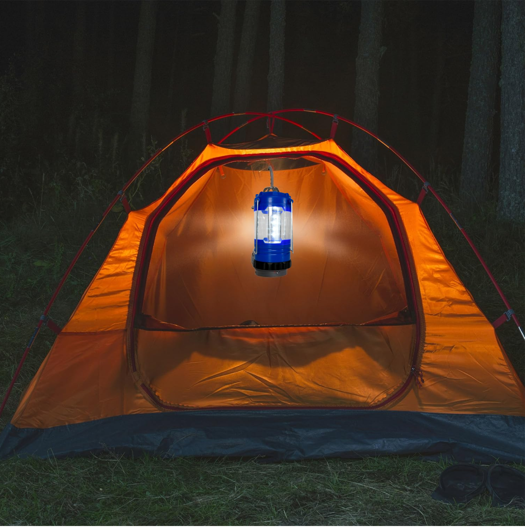 A blue and black LED lantern hangs inside an orange tent, casting a warm glow on the interior.