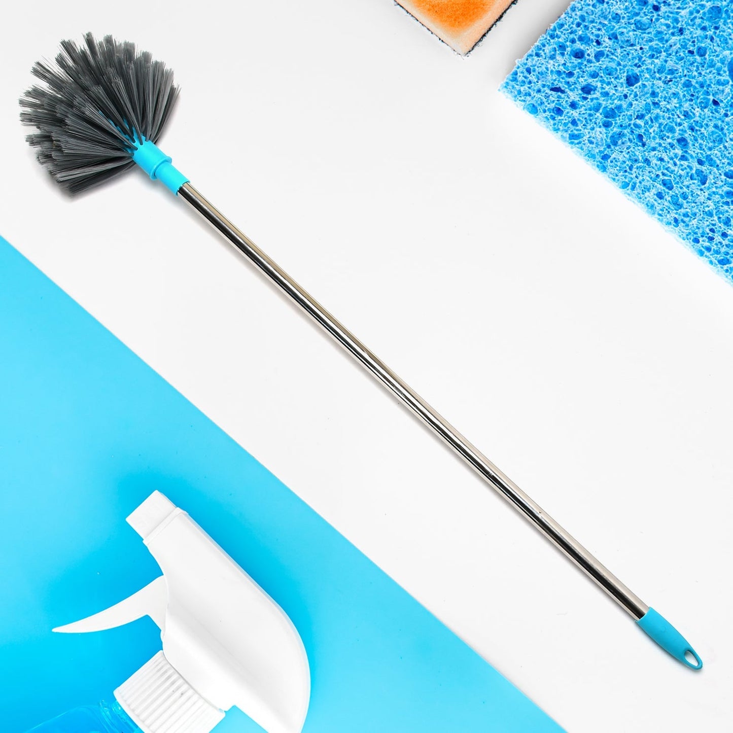 Extendable cobweb cleaning brush with stainless steel handle reaching a high ceiling.