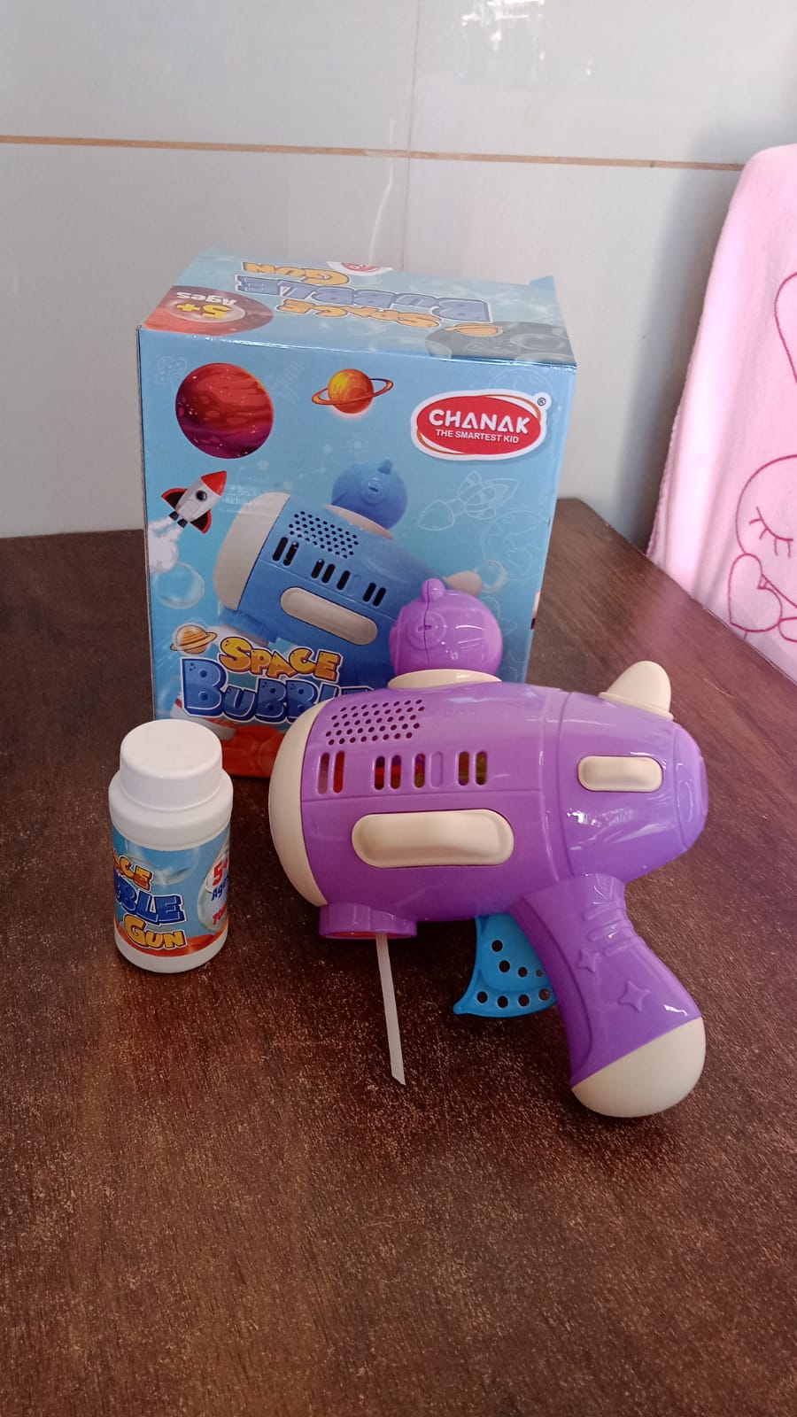 Lifestyle shot of children enjoying the bubble gun toy in a park.