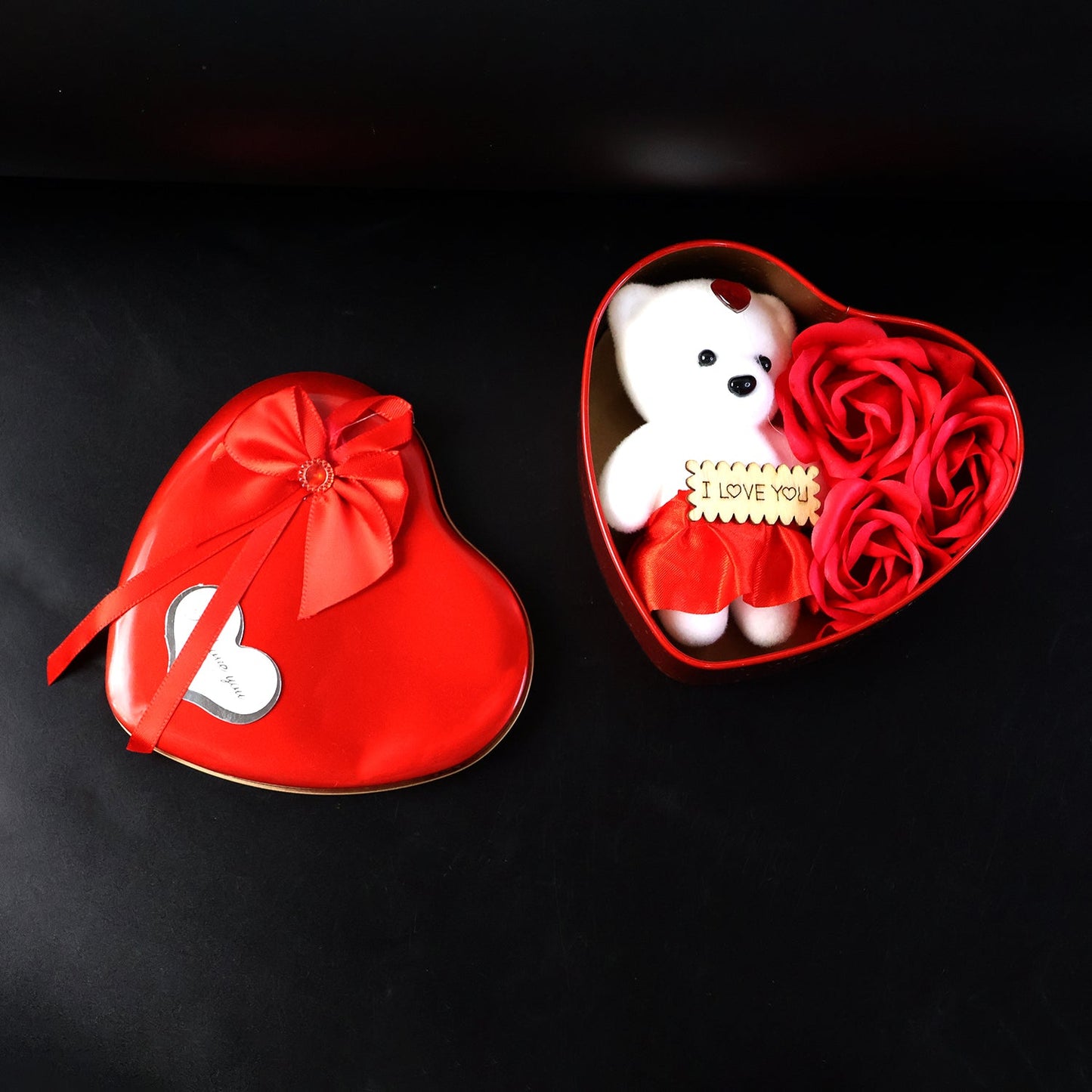 Top view of heart shaped Valentine’s gift box with teddy bear and roses