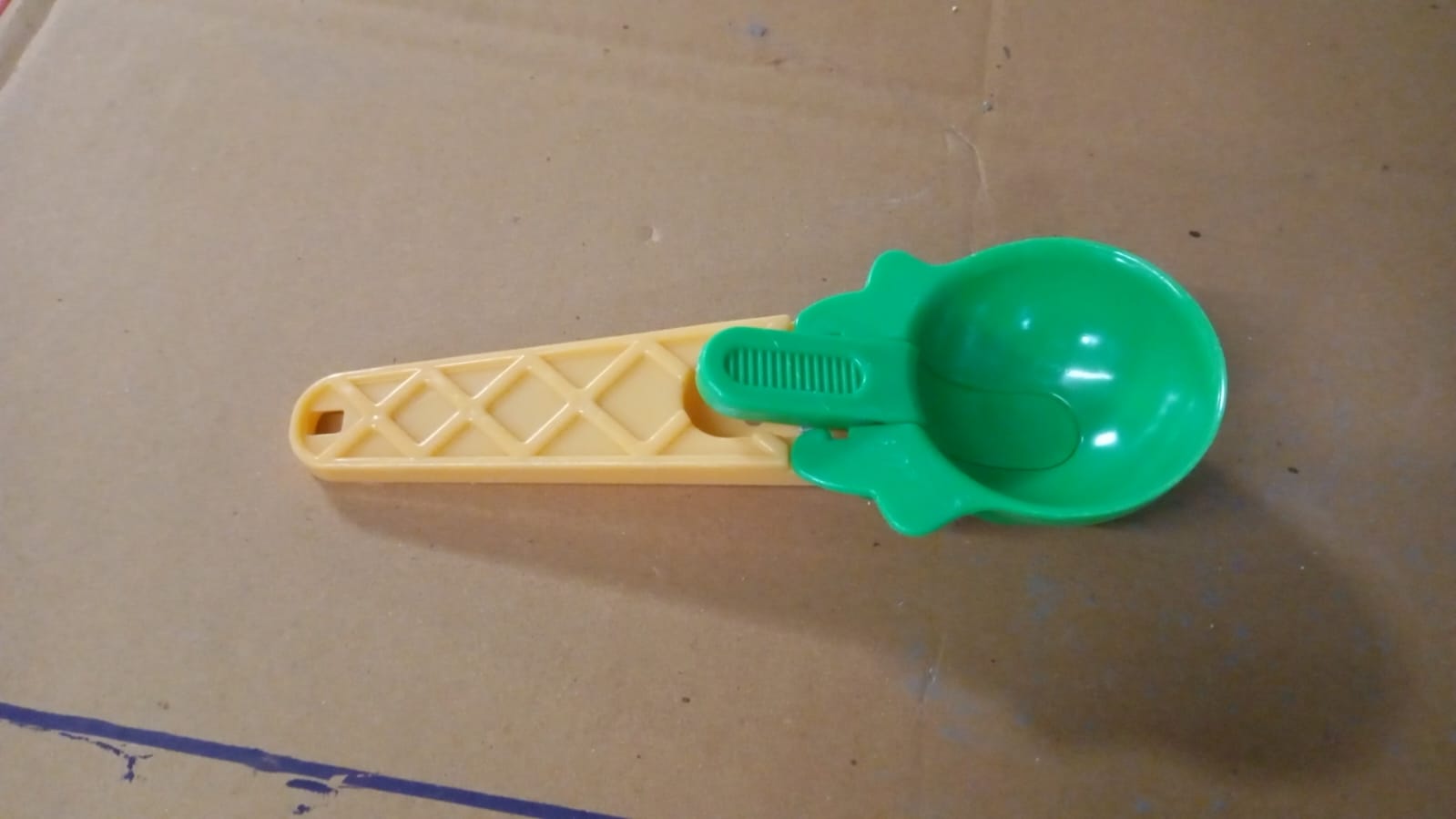 Kitchen setup featuring plastic ice cream scooper with trigger